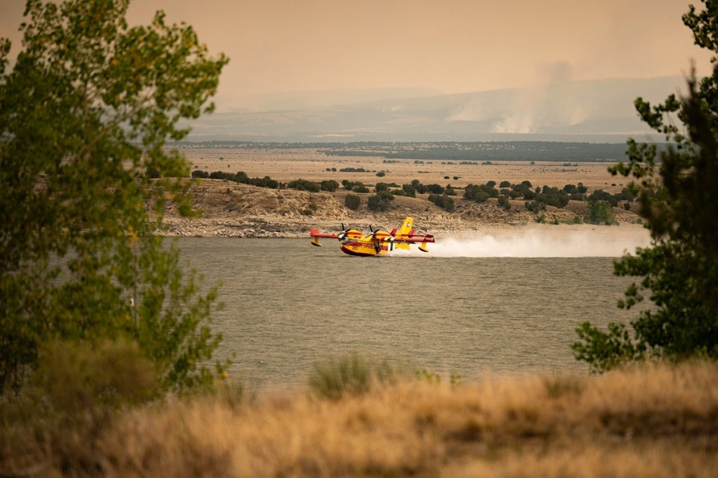 A fire response aircraft gathers water from Lake Pueblo to fight the Aspen Acres Fire