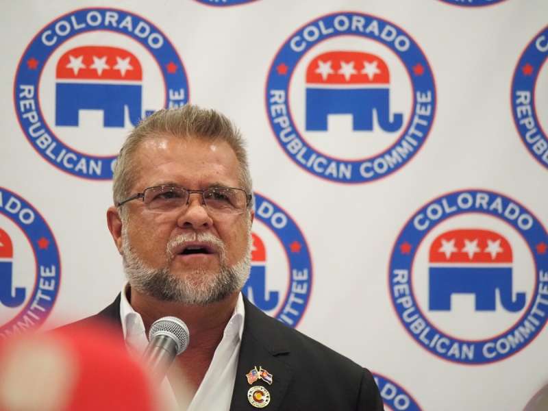 Victor Marx speaks to the public in front of a backdrop banner that reads "Colorado Republican Committee"