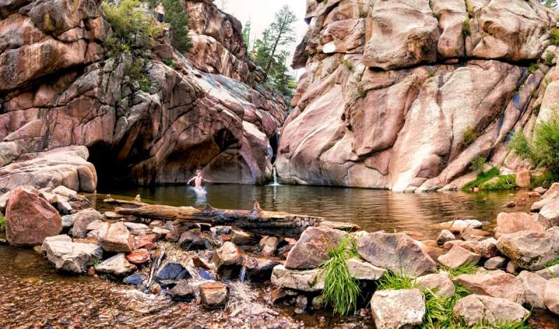 A young man swims in one of the many waterfalls in Colorado