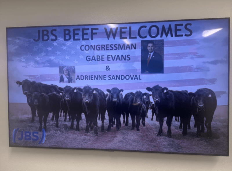 A screen in the lobby of the JBS meatpacking plant in Greeley, showing a welcome message for Evans and his aide. (Photo via Colorado Times Recorder; provided by UFCW7)